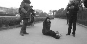 鄭大姐坐在地上，警方趕到進(jìn)行施救。（視頻截圖由警方提供）