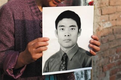 5月19日，朝陽(yáng)北路，母親捧著張東文的遺像。新京報(bào)記者 侯少卿 攝