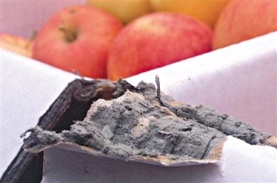 8月29日，新發(fā)地市場，一箱用“加重紙箱”包裝的蘋果正待售，紙箱夾層內(nèi)灰黑色的增重填充物清晰可見