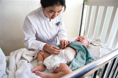 昨日，北京兒童醫(yī)院，護(hù)士為即將出院的被扎鋼針女嬰檢查傷口恢復(fù)情況。記者 高瑋 攝