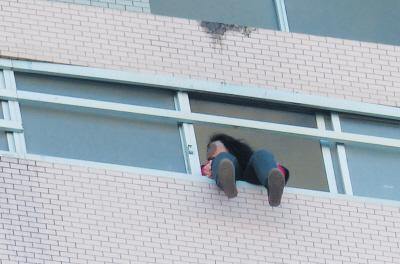 28樓的窗臺(tái)上坐著一名女子，其兩條腿耷拉在室外，不停地?cái)[動(dòng)。