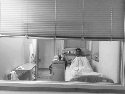 楊杰在醫(yī)院隔離病房中，沖記者揮了揮手。