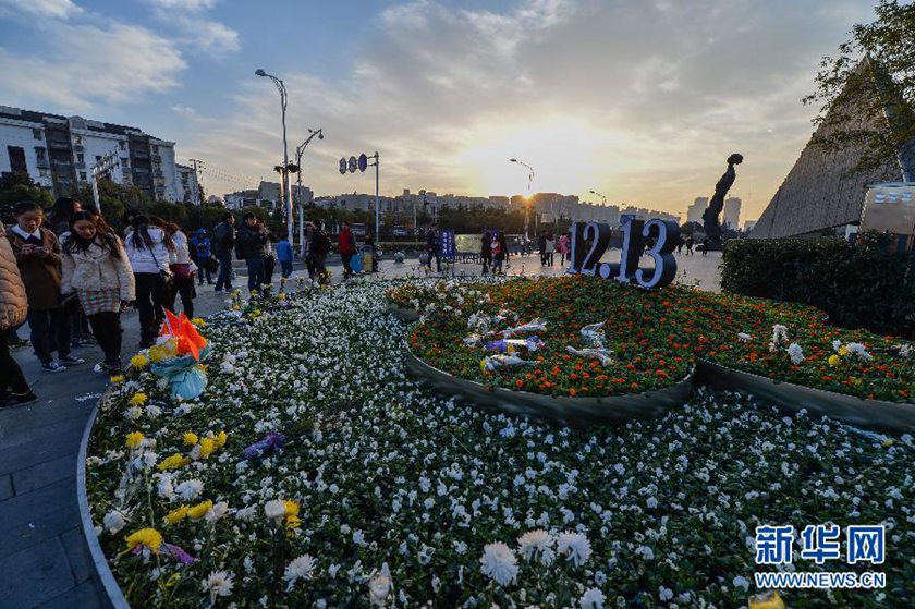 12月14日,觀眾在侵華日軍南京大屠殺遇難同胞紀念館前的“12·13”花壇上擺放鮮花祭奠遇難同胞。新華社記者 沈鵬 攝