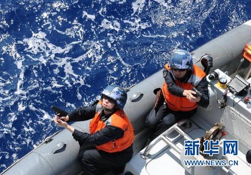 　3月28日，十余名臨檢拿捕隊員乘小艇駛至模擬可疑商船下方水面。