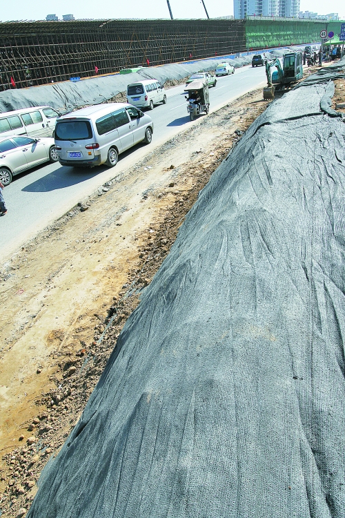 豐樂路與北三環(huán)交叉口，修路的土被歸置得整整齊齊，并用黑網(wǎng)覆蓋，既保暢通又避免了揚塵。