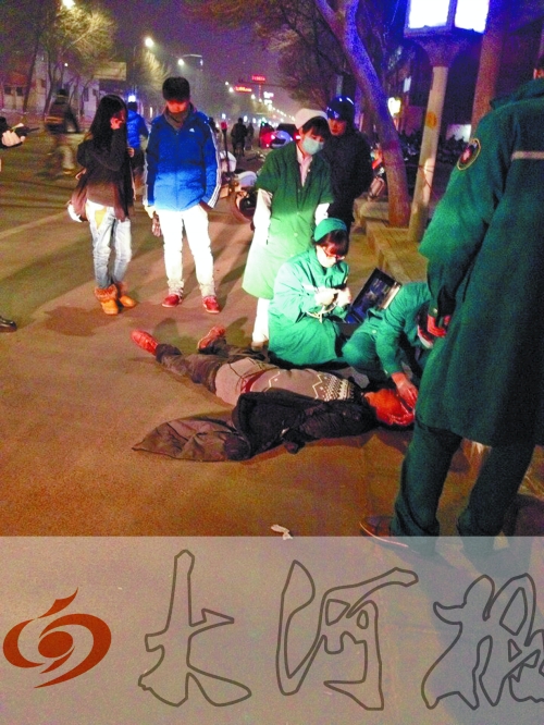 醉漢躺在地上，醫(yī)護(hù)人員對(duì)其進(jìn)行檢查。